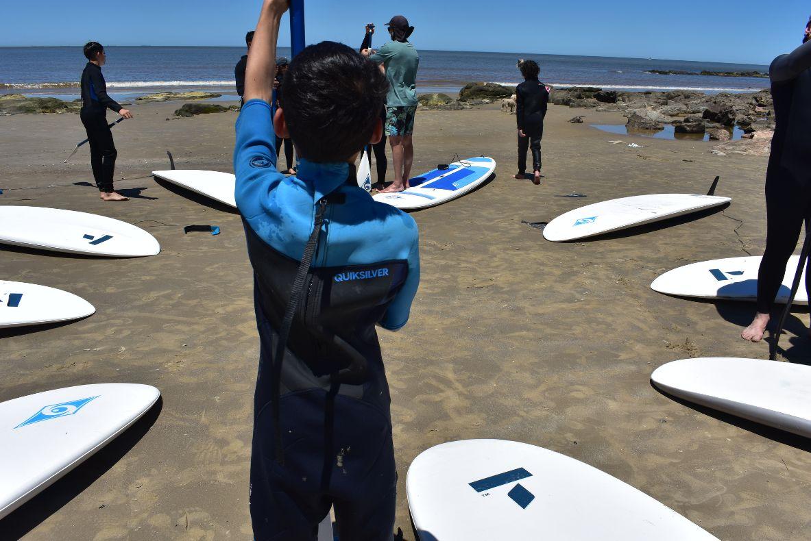 Niños y niñas se preparan para surfear. 