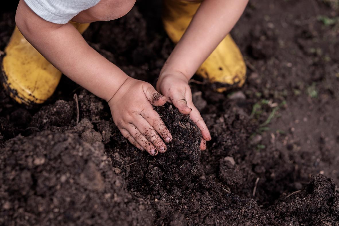 imagen ilustrativa niño o niña jugando con tierra