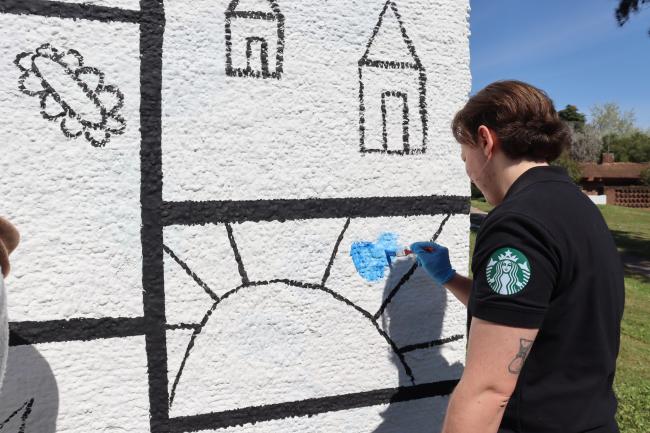 Voluntario de Starbucks pinta mural en el Programa Montevideo de Aldeas Infantiles.